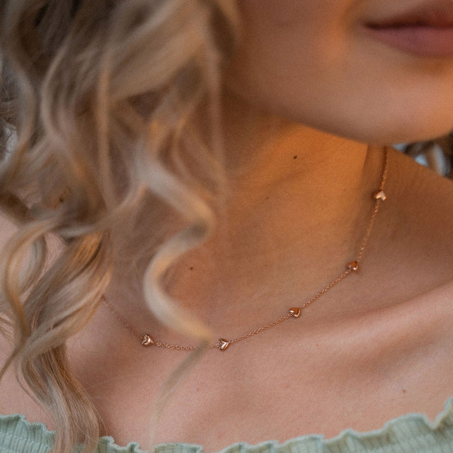 Zarte Alohi Heart Kette in Roségold mit kleinen Herzen, getragen am Schlüsselbein, pure feminine Eleganz von PURELEI.