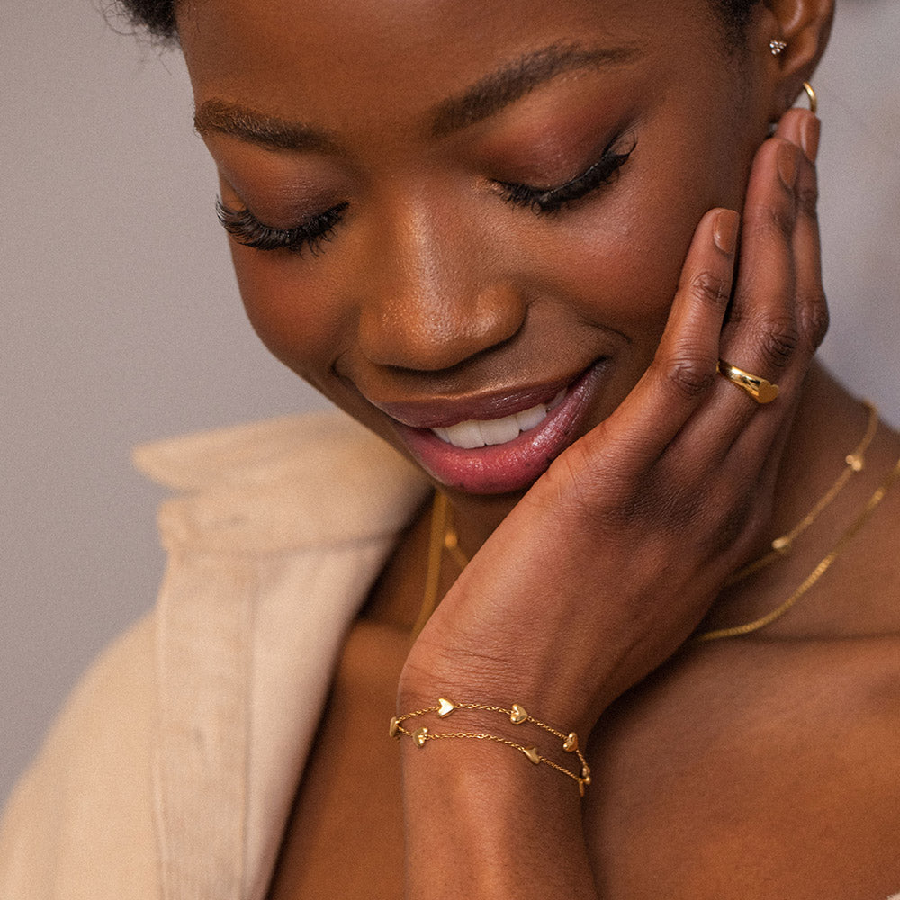 PURELEI Alohi Heart Armband aus 18K Gold, zart mit kleinen Herzen, elegant am Handgelenk getragen.