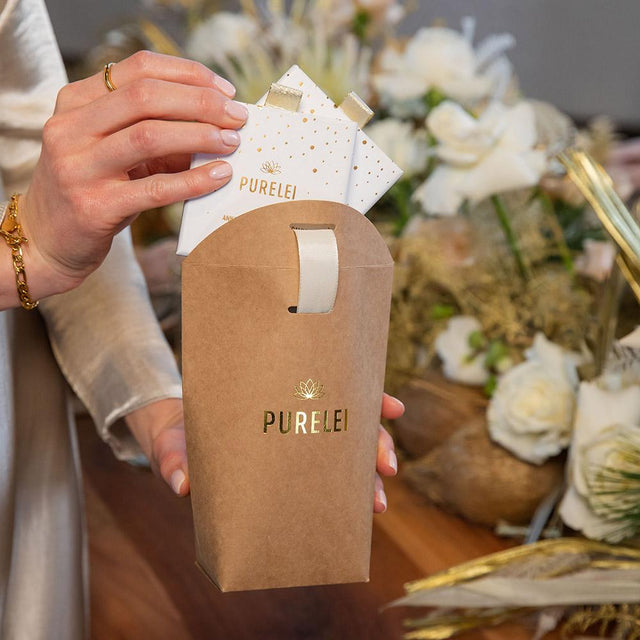 PURELEI Geschenkverpackung Basic aus braunem Kraftpapier mit goldener Prägung und cremeweißem Band, stilvoll und elegant.