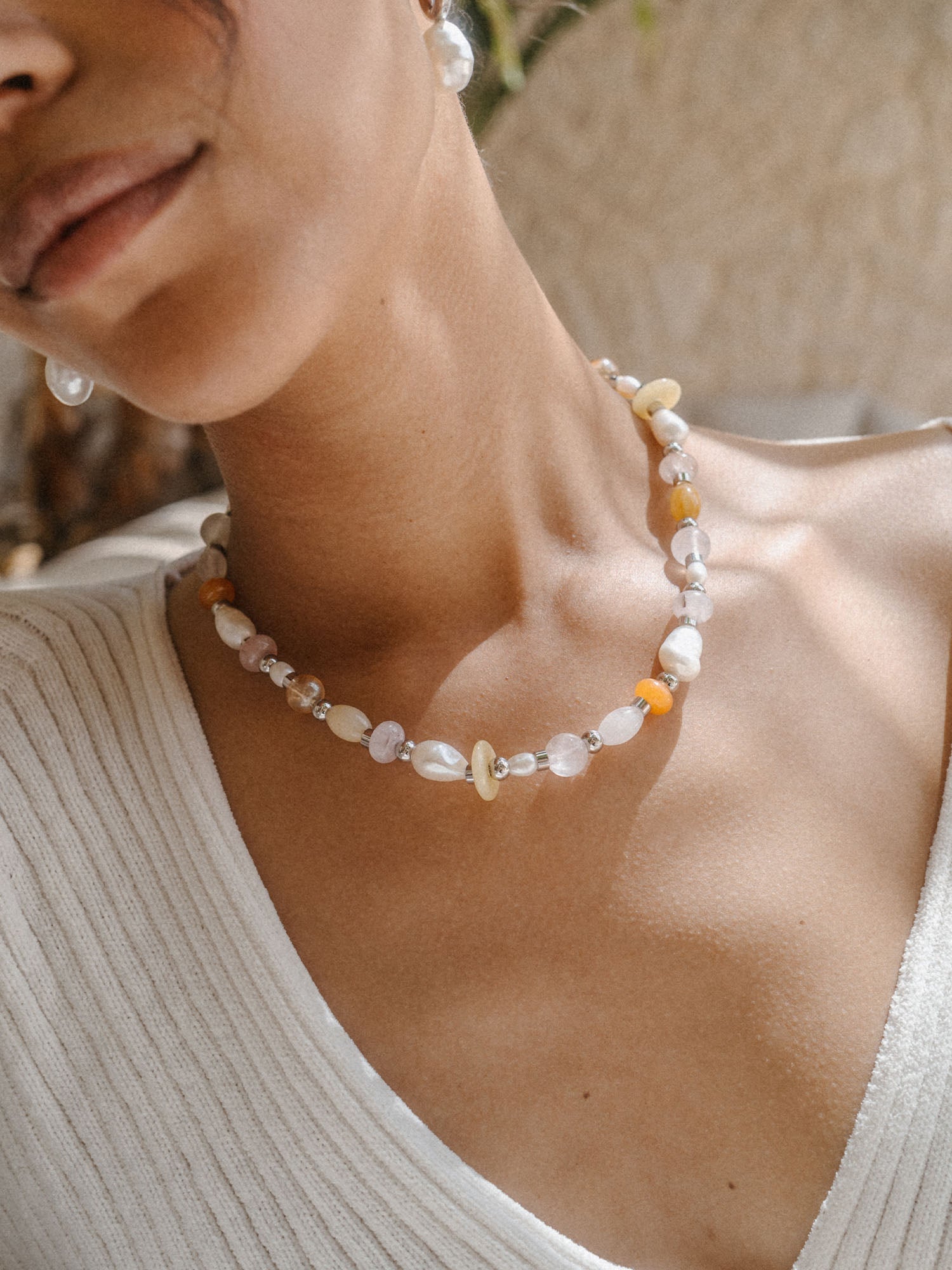 Perlenkette mit Muscheldetails, getragen in warmem Licht, von PURELEI.