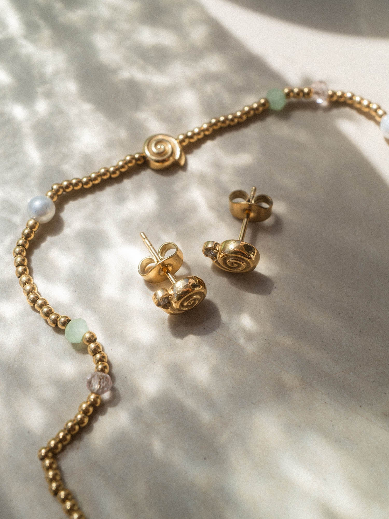 Silberne Ohrringe mit spiralförmigem Design und Perlen, inspiriert von PURELEI.