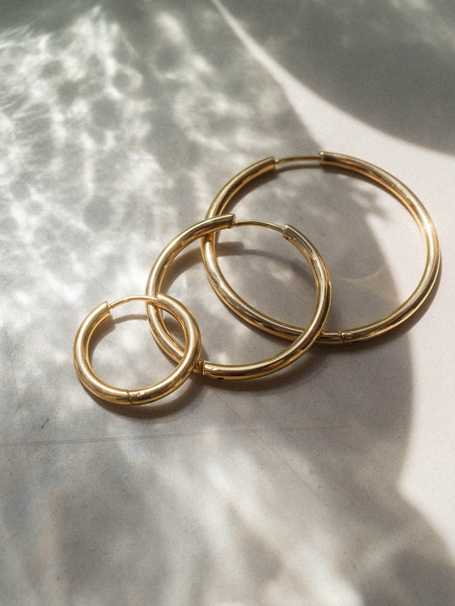 Drei silberne Creolen von PURELEI in verschiedenen Größen, elegant auf hellem Untergrund.