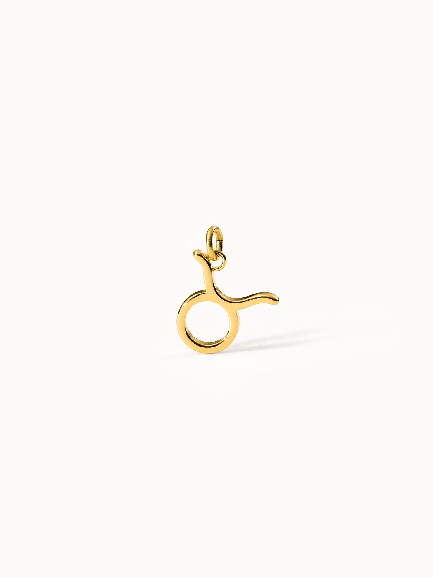 Stier Zodiac Charm aus vergoldetem Edelstahl, minimalistisches Design auf hellem Hintergrund, PURELEI Eleganz.