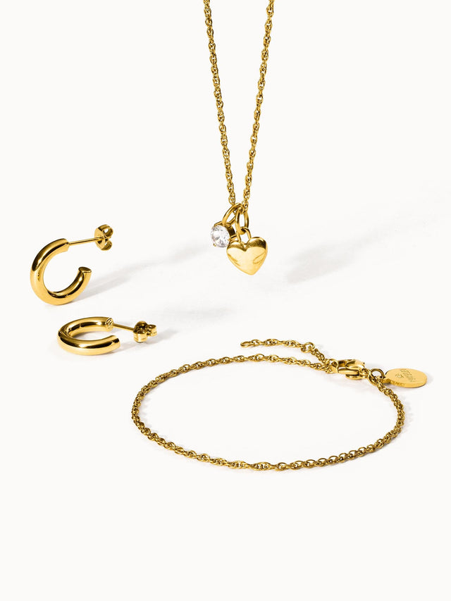 Goldene Ohrringe und Kette mit Herz-Anhänger von PURELEI, elegant und feminin.