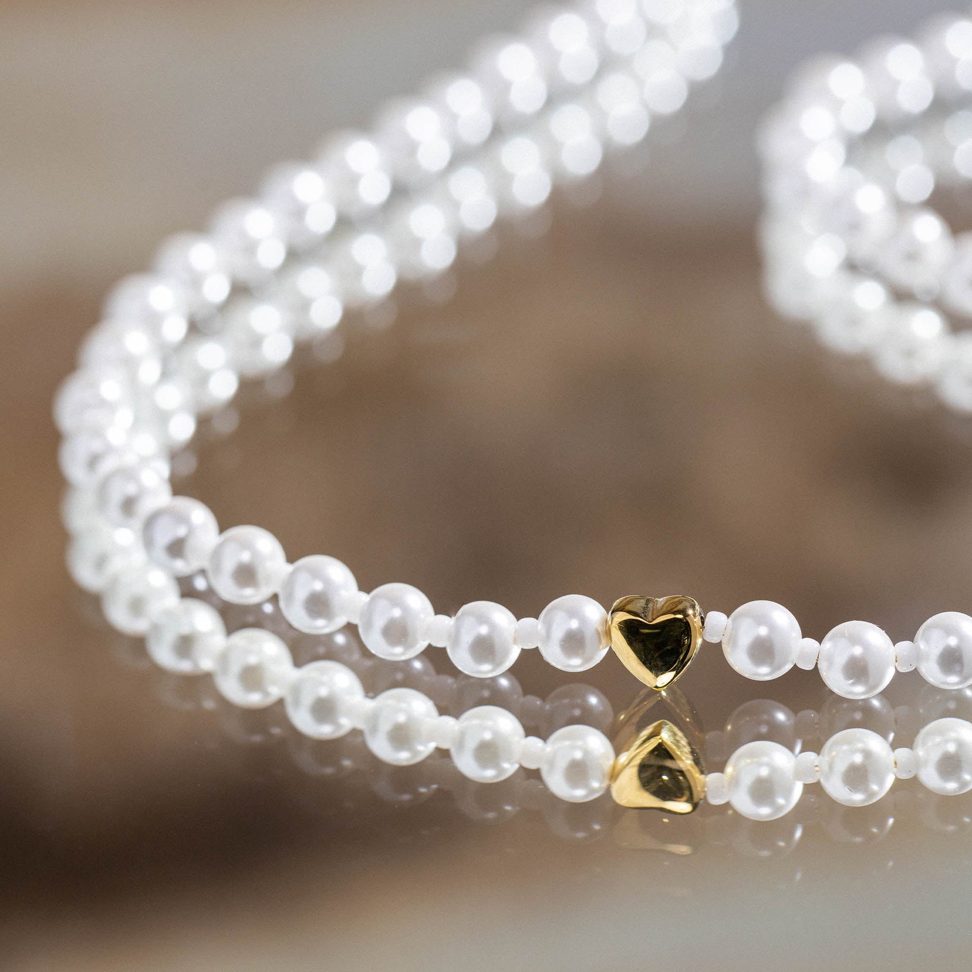 Lovely Kette von PURELEI mit weißen Muschel- und Glasperlen sowie goldenem Herzanhänger, elegant und feminin.