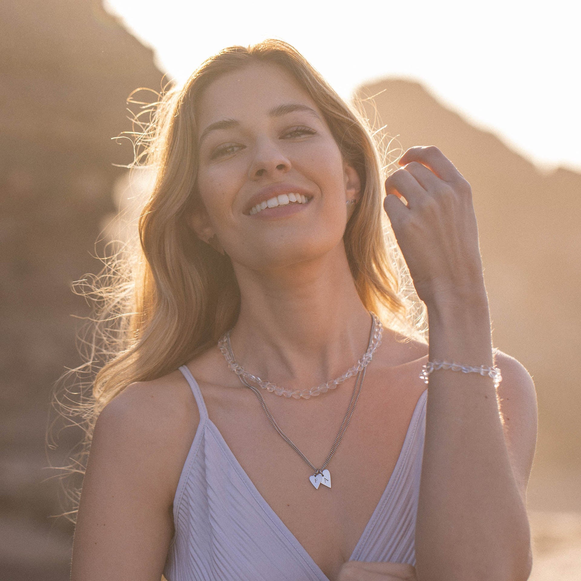 Silberne Kette mit Herz-Anhänger und zartem Armband, PURELEI, in warmem Sonnenlicht.