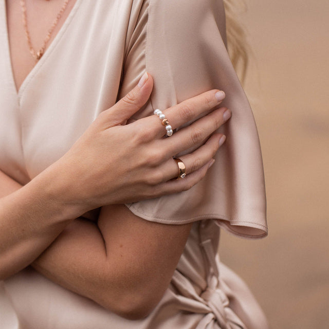 PURELEI Anxiety Lovely Ring aus Muschelperlen mit Herzdetail, zart und elegant am Handfinger getragen.