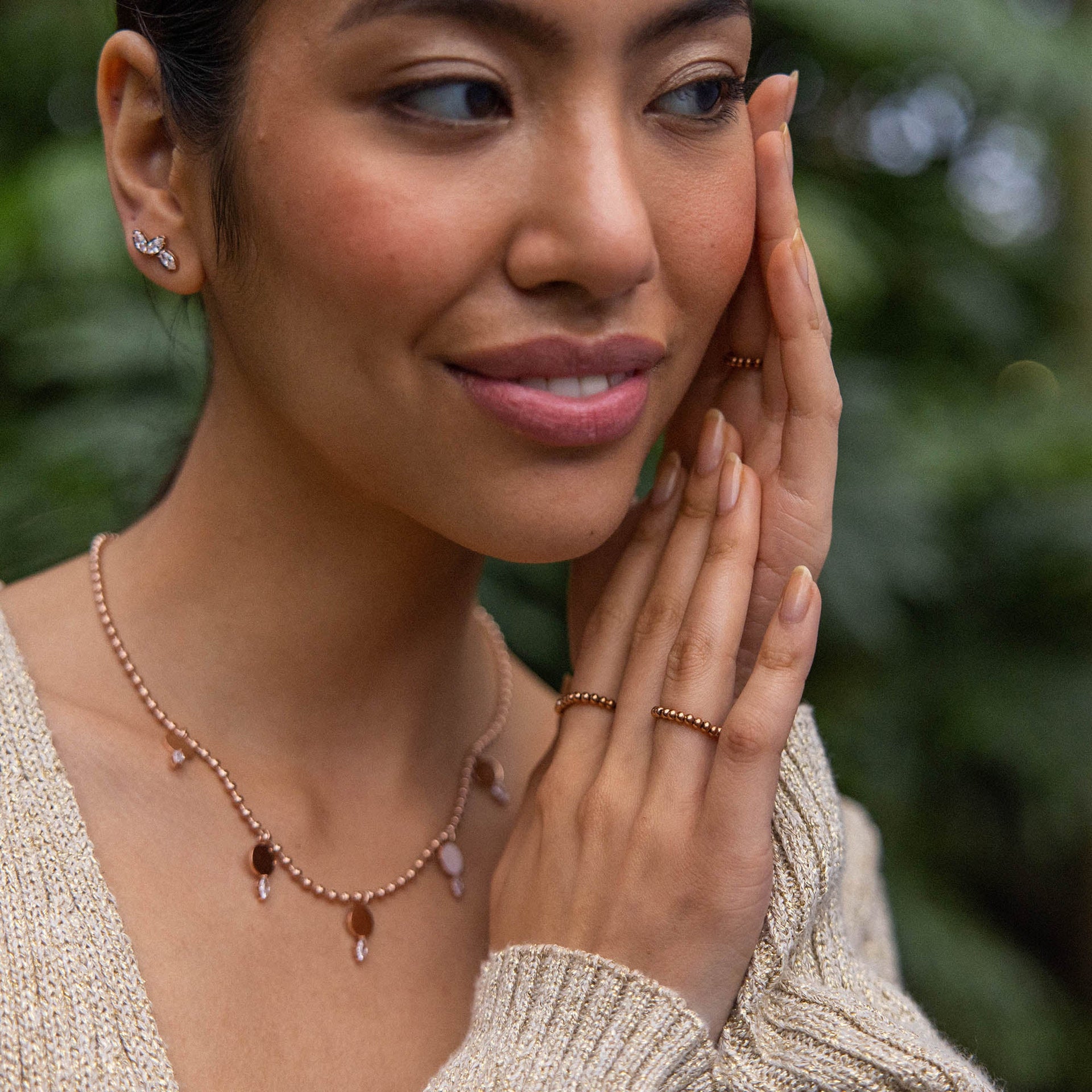 Roségoldene Kette mit Anhängern, getragen von einer Frau, PURELEI inspiriert von Natur und Eleganz.