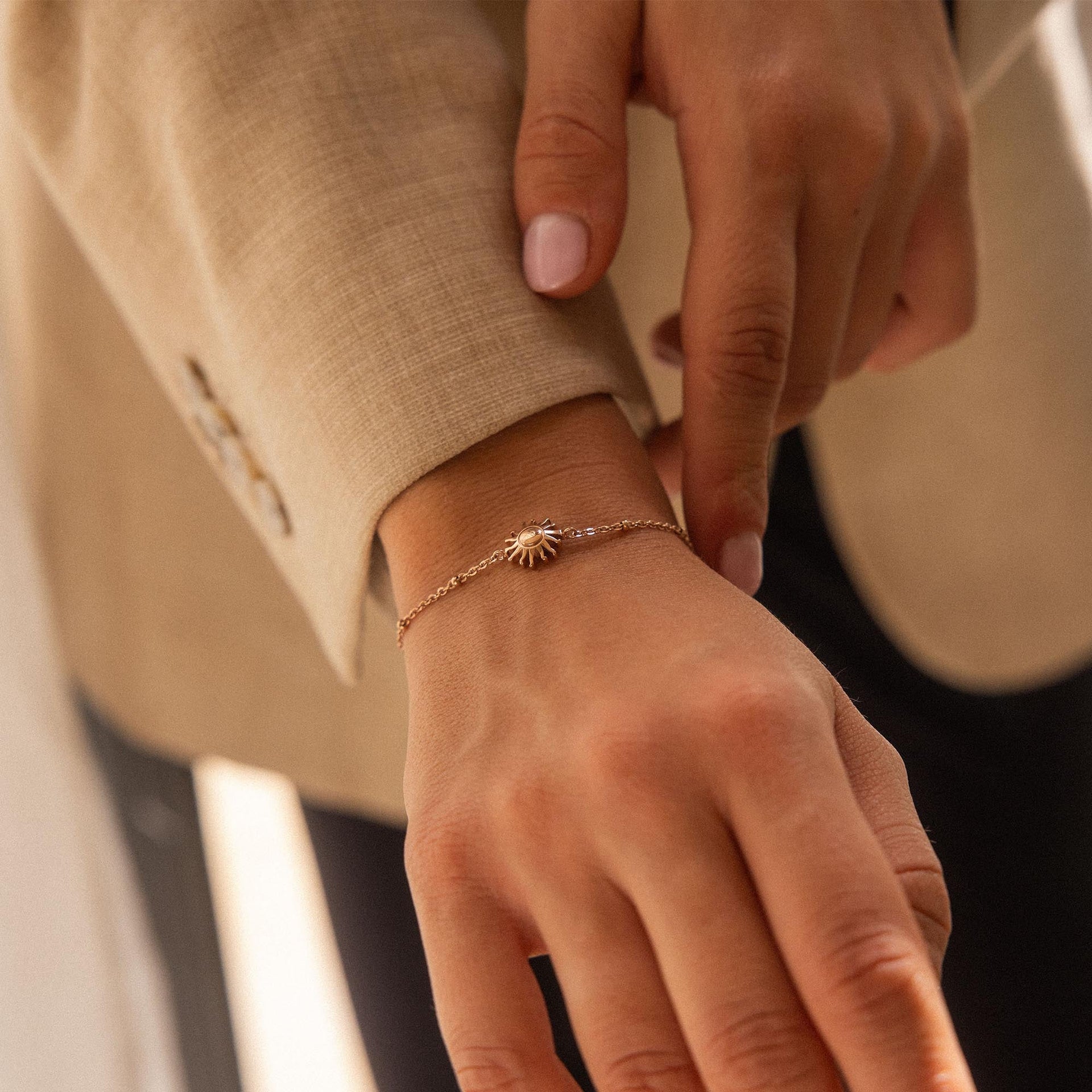 Roségoldenes Armband mit Sonnenmotiv, getragen am Handgelenk, von PURELEI.