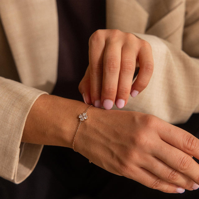 Silbernes Armband mit floralen Anhänger, getragen am Handgelenk, PURELEI Stil.