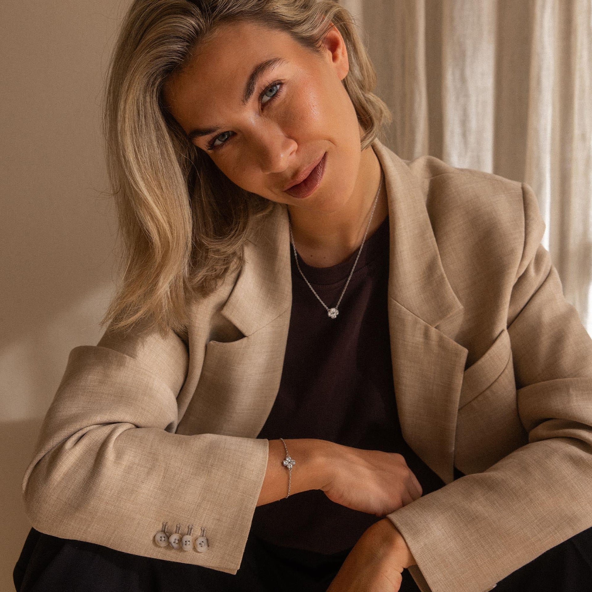 Elegante PURELEI Kette mit zartem Anhänger, getragen in warmem Licht, femininer Stil.