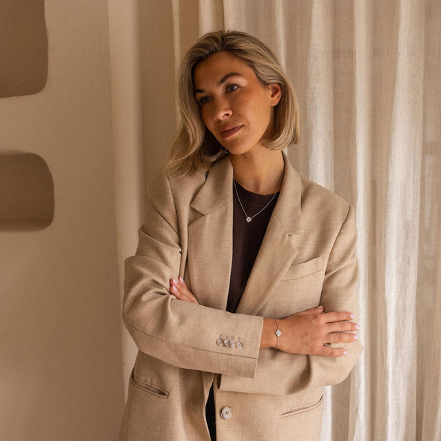 Elegante, allergenfreundliche PURELEI Kette mit zartem Anhänger, getragen in warmem Licht.