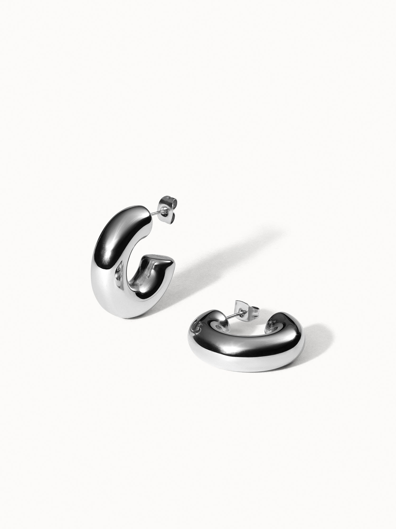 PURELEI Small Stellar Glow Ohrringe in Silber, nickelfrei, minimalistisch geschwungen, auf hellem Hintergrund präsentiert