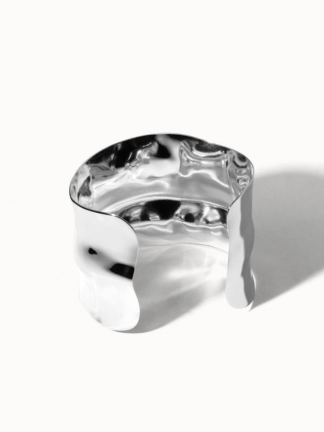 Silbernes, gewelltes Armband von PURELEI mit glänzender Oberfläche und modernem Design.