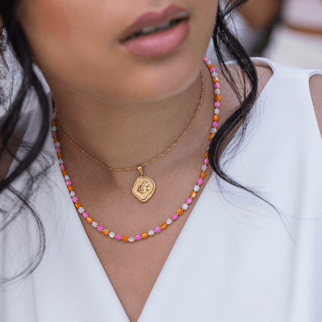 Zarte PURELEI Kette mit goldfarbenem Anhänger und bunten Perlen, elegant und feminin.