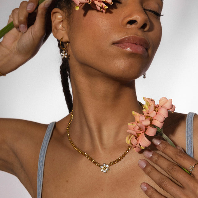 Roségoldene Kette mit blütenförmigem Anhänger, getragen mit floralen Akzenten, PURELEI.