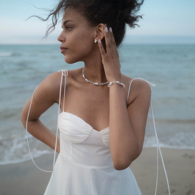 PURELEI Crystal Wave Armband aus vergoldetem Edelstahl mit schimmernden Keshi-Perlen am Strand getragen, elegant und feminin