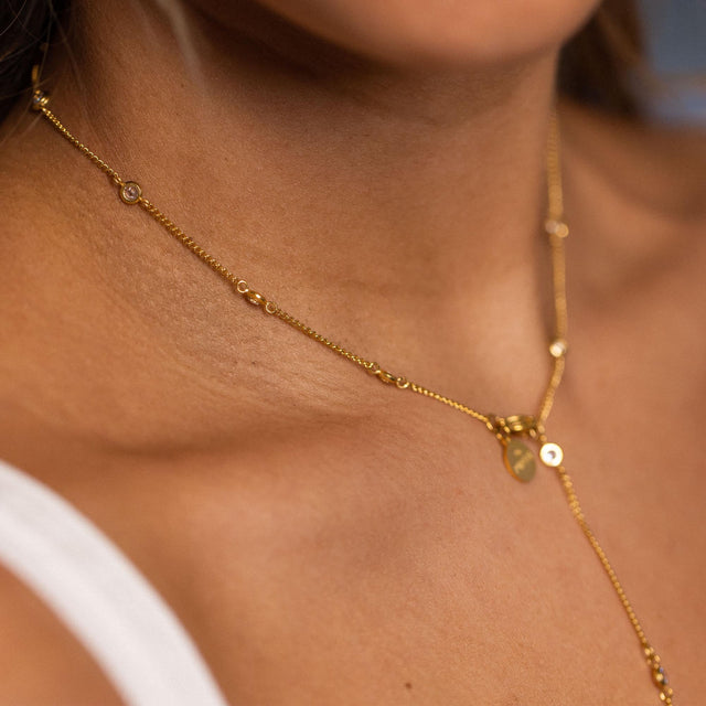 Roségoldene Kette mit zarten Anhängern, elegant am Hals getragen – PURELEI.