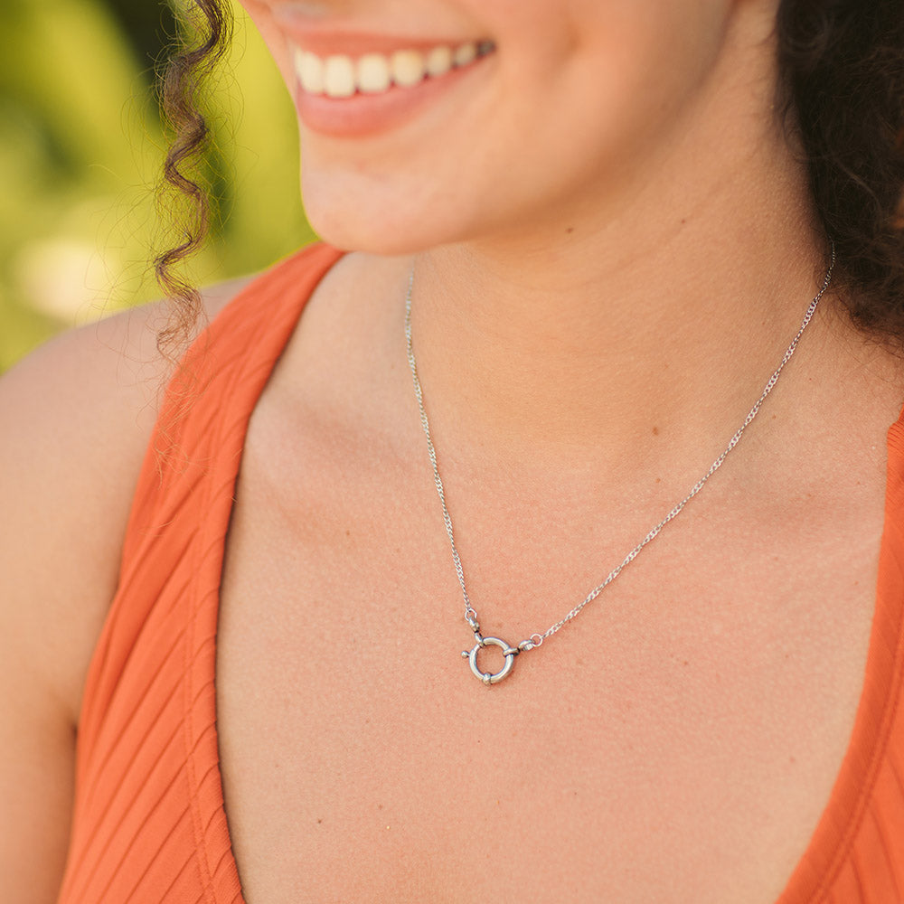 Silberne, nickelfreie Lokahi Charm Kette von PURELEI mit filigraner Kette, getragen im warmen Tageslicht.