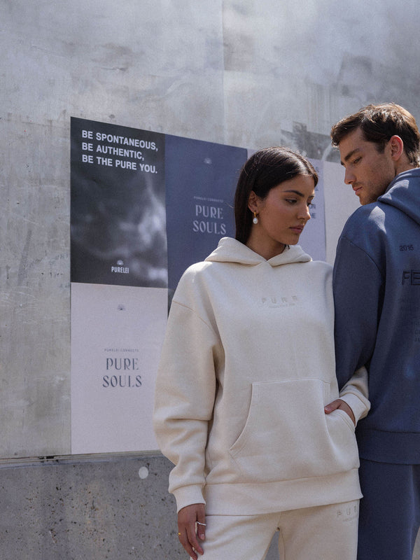 Beige Kapuzenpullover von PURELEI, lässig und modern, umgeben von urbanem Flair.