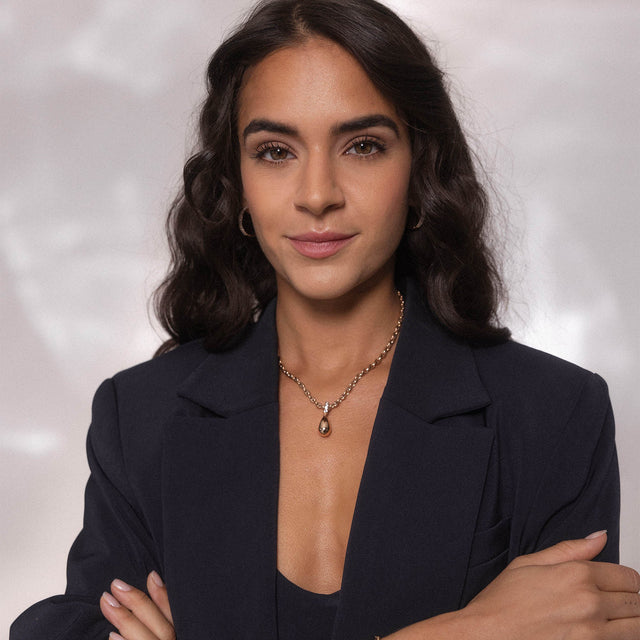 Elegante Kette mit Tropfenanhänger, silberfarben, getragen von einer Frau in einem blauen Blazer – PURELEI.