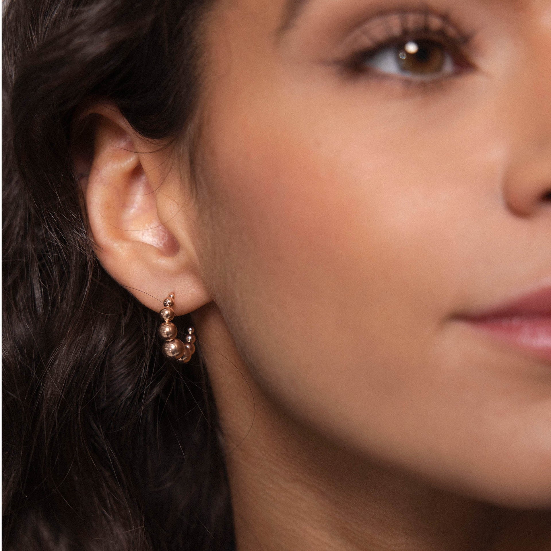 Roségoldene Creolen mit runden Details, getragen von einer Frau, PURELEI inspiriert.