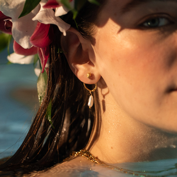 PURELEI Elua Ohrringe in Gold mit schimmernder Keshi-Perle, getragen im Wasser, elegant und feminin.