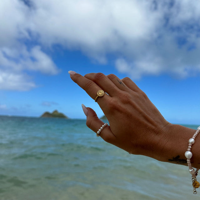 Waina Ring aus vergoldetem Edelstahl mit filigranem Coin, getragen am Strand – PURELEI, elegant und femininer Schmuck.