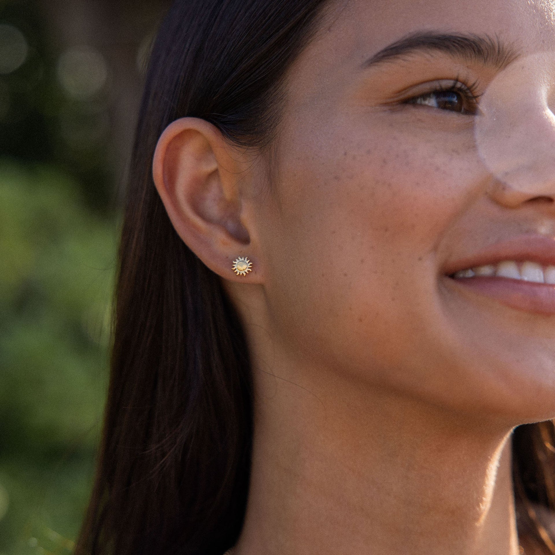 Roségoldene Ohrringe mit Sonnenmotiv, getragen in natürlicher Umgebung – PURELEI.