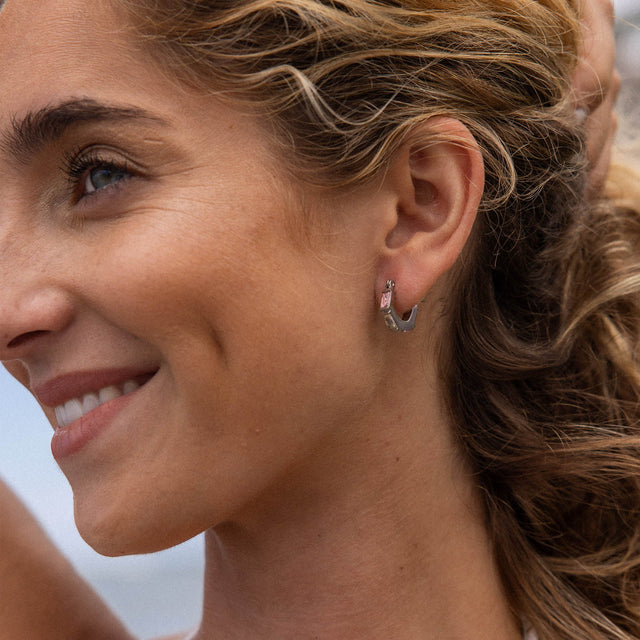 Silberne Creolen mit elegantem Design, getragen von einer lächelnden Frau, PURELEI.