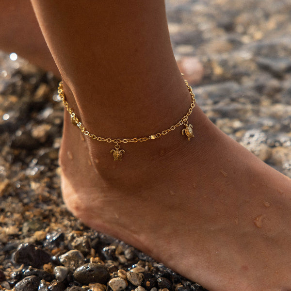 Silbernes Fußarmband mit Schildkröten-Anhängern, getragen am Strand, von PURELEI.