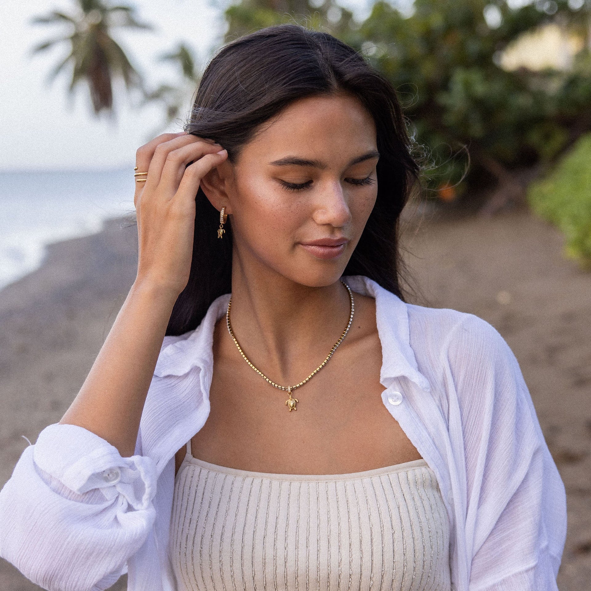 Silberne Kette mit Muschel-Anhänger und Ohrringen, PURELEI, am Strand getragen.