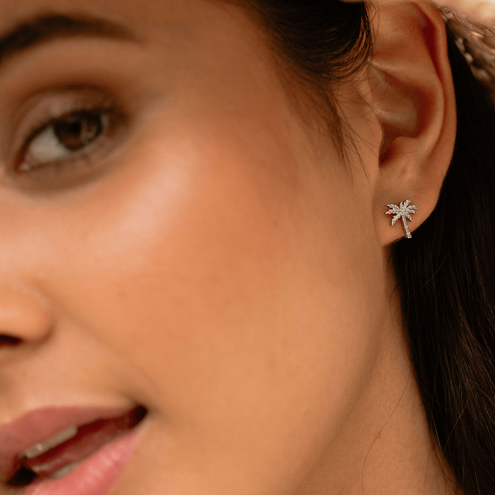 Kleine silberne Palm Ohrringe aus Edelstahl, zart und elegant getragen, PURELEI Island-Spirit Schmuck.