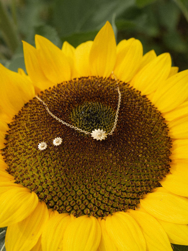Goldene Blütenkette von PURELEI auf Sonnenblume, strahlend und lebendig.