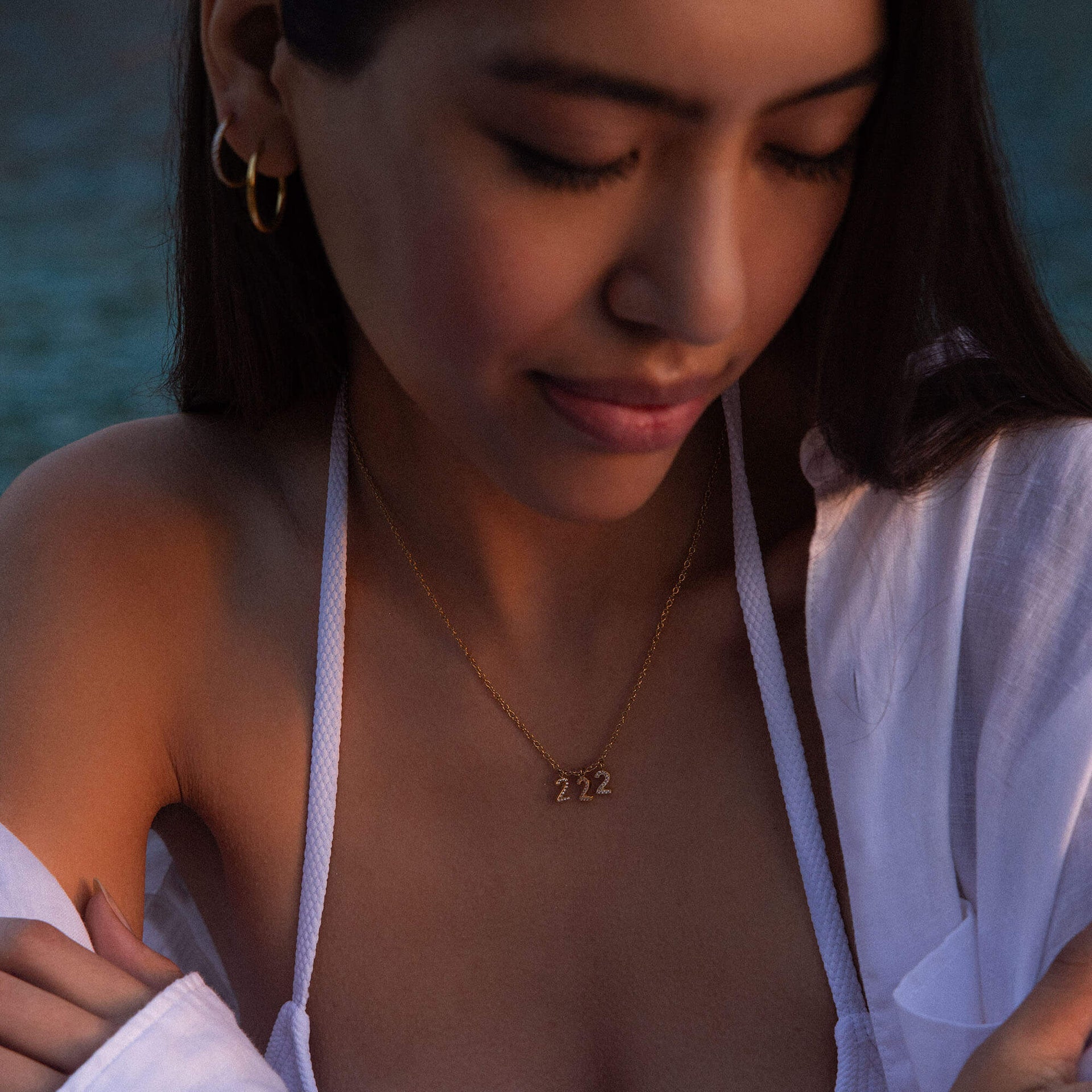 222 Kette aus 18K Gold mit Zirkonia, warmes Licht am Abend, feines Schmuckstück.