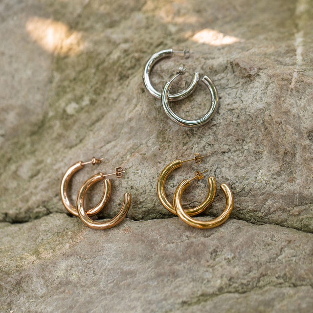 Kumu O Creolen in Gold, Silber und Roségold liegen auf natürlichem Stein – zeitlos, elegant, nickelfrei von PURELEI.