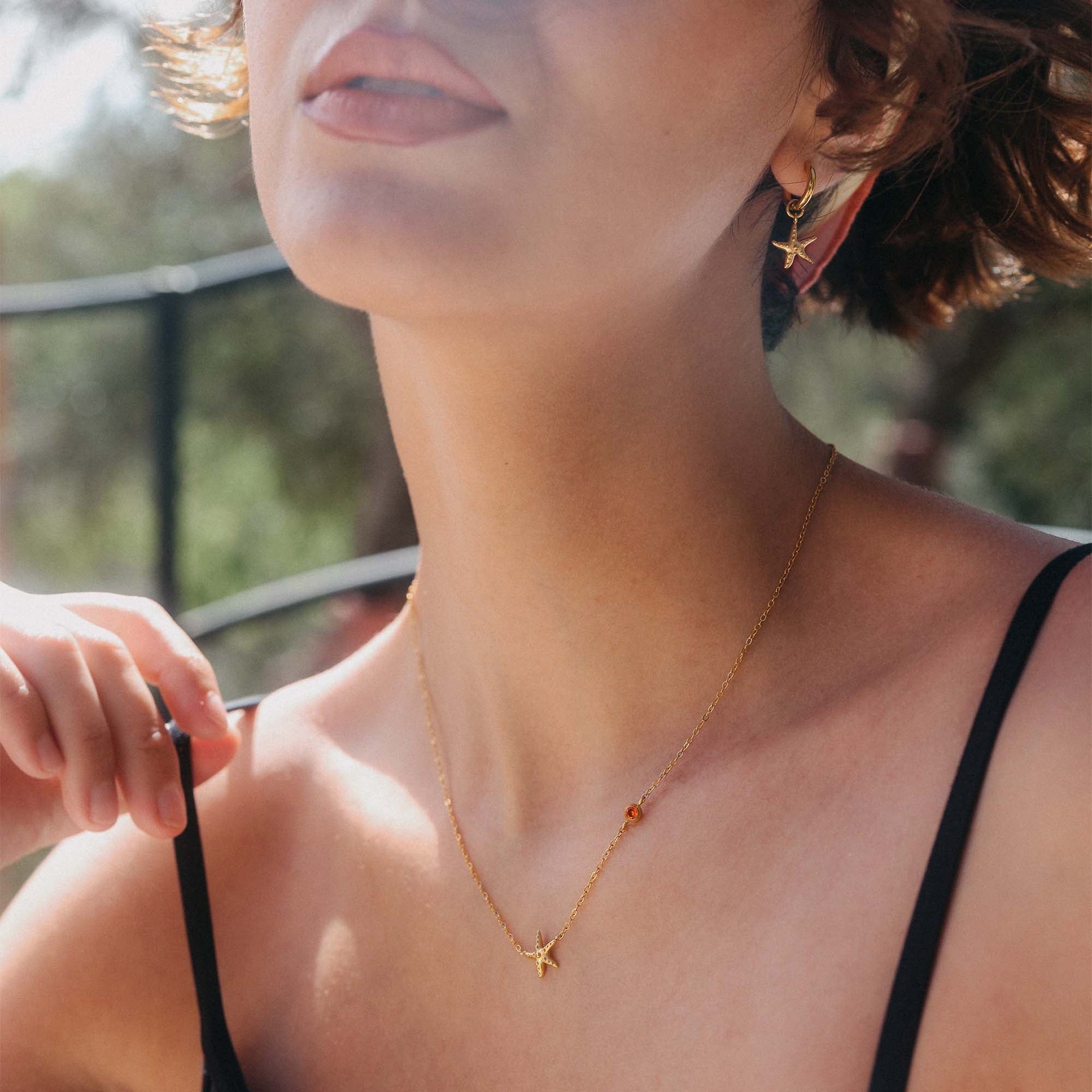 Zarte roségoldene Kette mit Stern-Anhänger, getragen im Sonnenlicht – PURELEI.