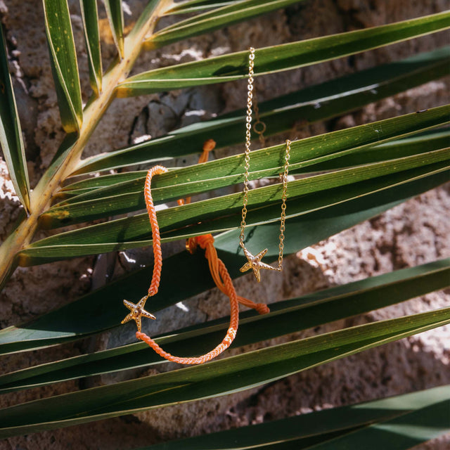 Zarte Kette mit Seestern-Anhänger aus Silber, umgeben von tropischen Blättern – PURELEI.