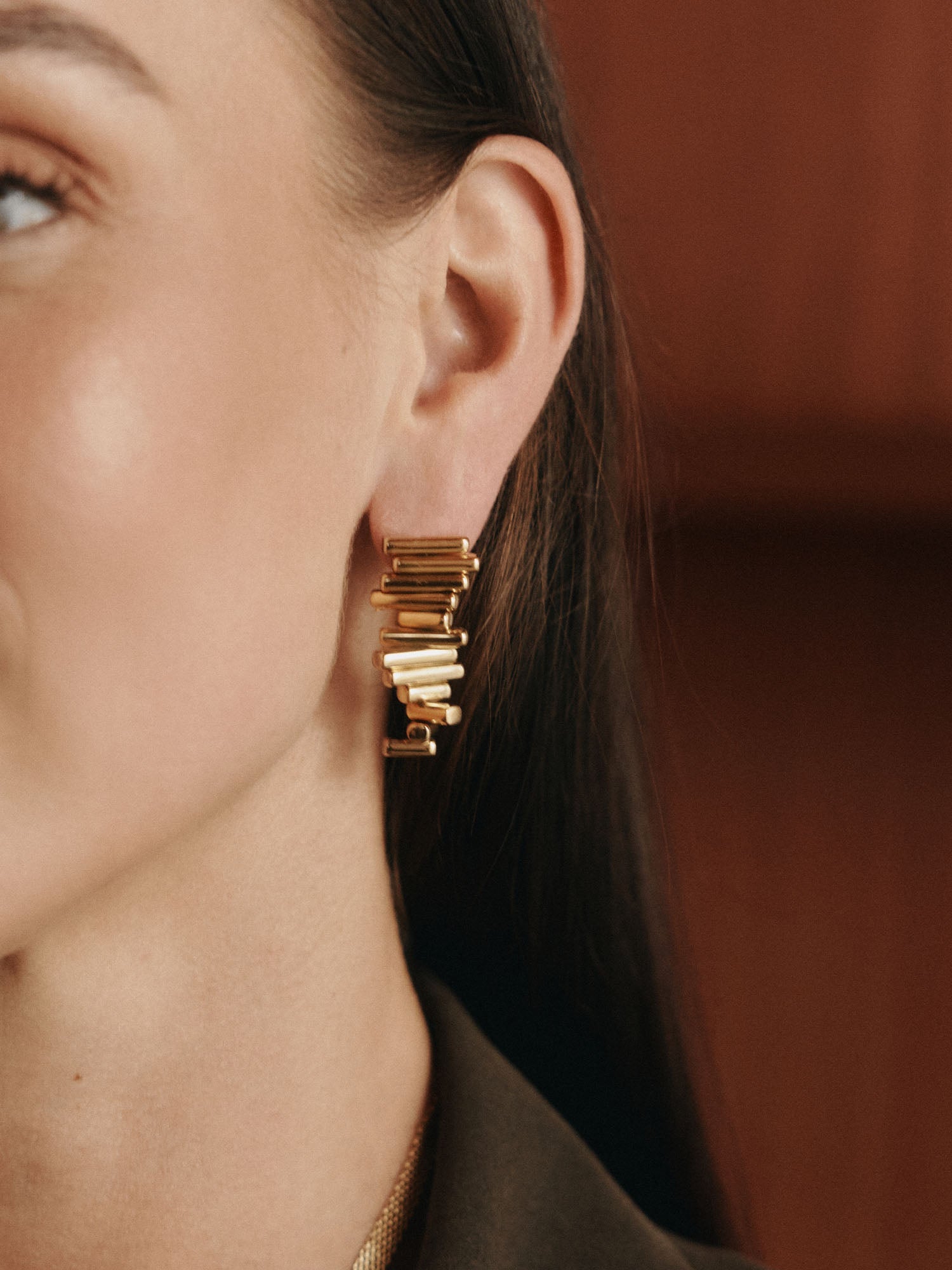 Roségoldene Ohrringe mit modernem Design, getragen von einer Frau, PURELEI.