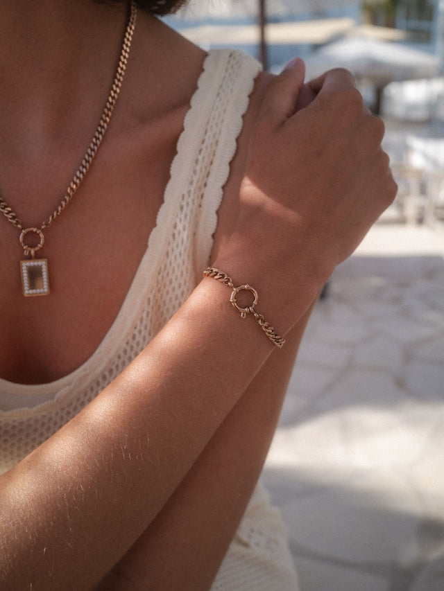 Bold Charm Armband von PURELEI in 14K Gold mit großer Panzerkette und Charm-Verschluss, elegant am Handgelenk getragen.