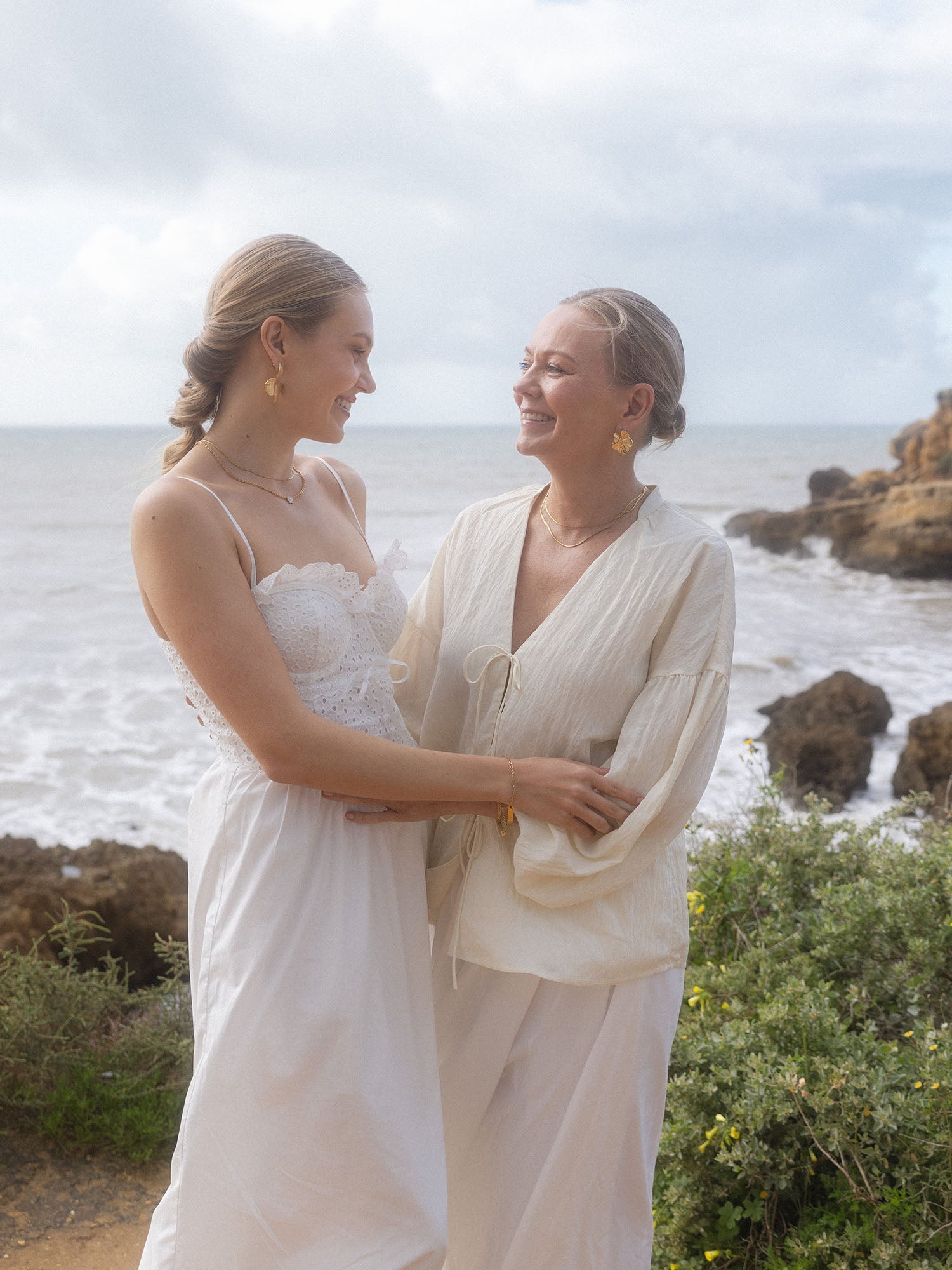 PURELEI Petal Ohrringe aus vergoldetem Edelstahl in Blütenform, warmes Strandlicht, feminine Eleganz am Meer.