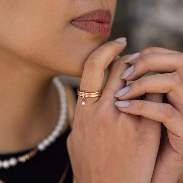 Roségoldene Ringe mit minimalistischen Designs, getragen von einer Hand, PURELEI.