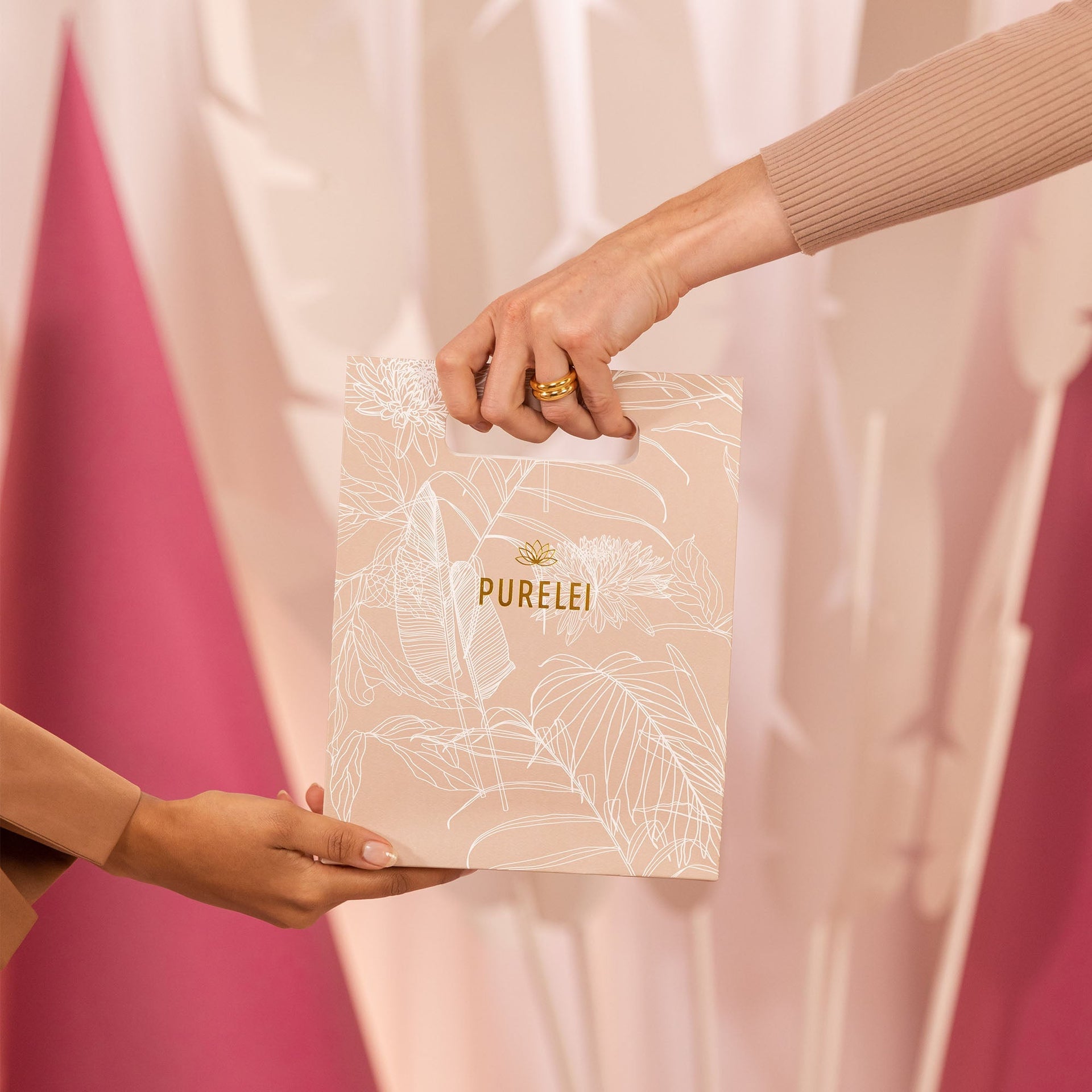 Hochwertige PURELEI-Tüte in sanften Farben, umgeben von warmen, eleganten Texturen.
