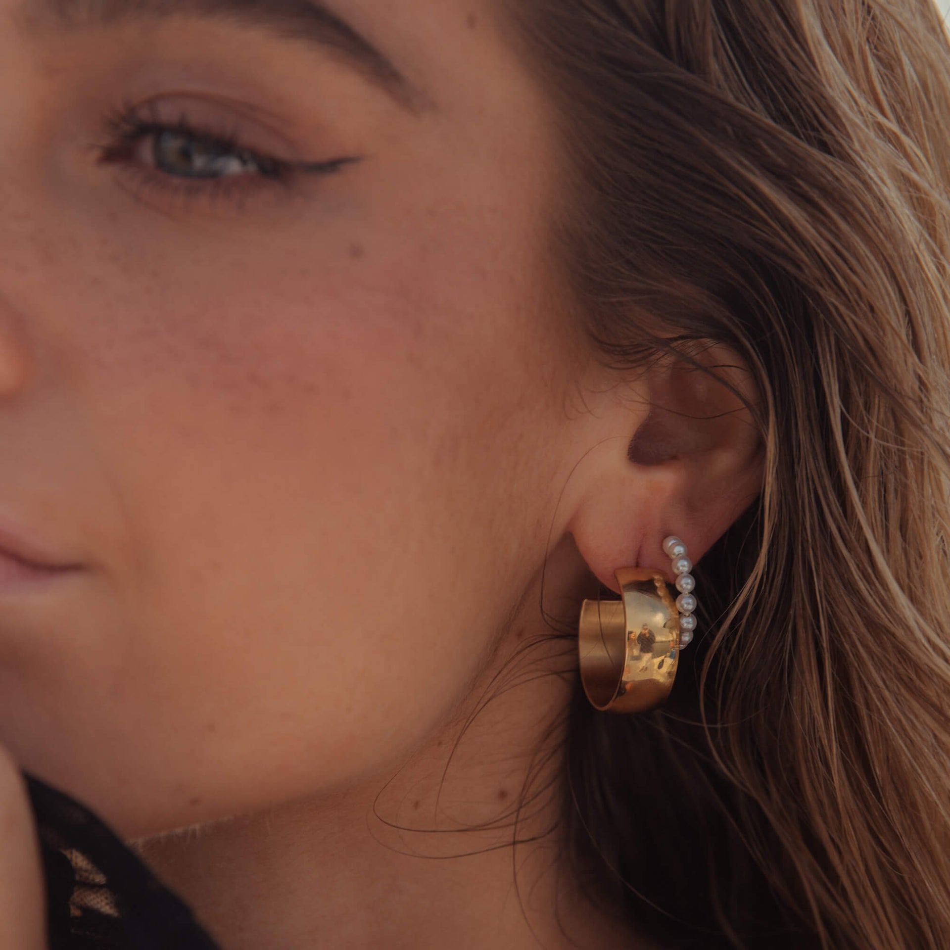 Roségoldene Creolen mit Perlen, getragen von einer Frau, PURELEI inspiriert.