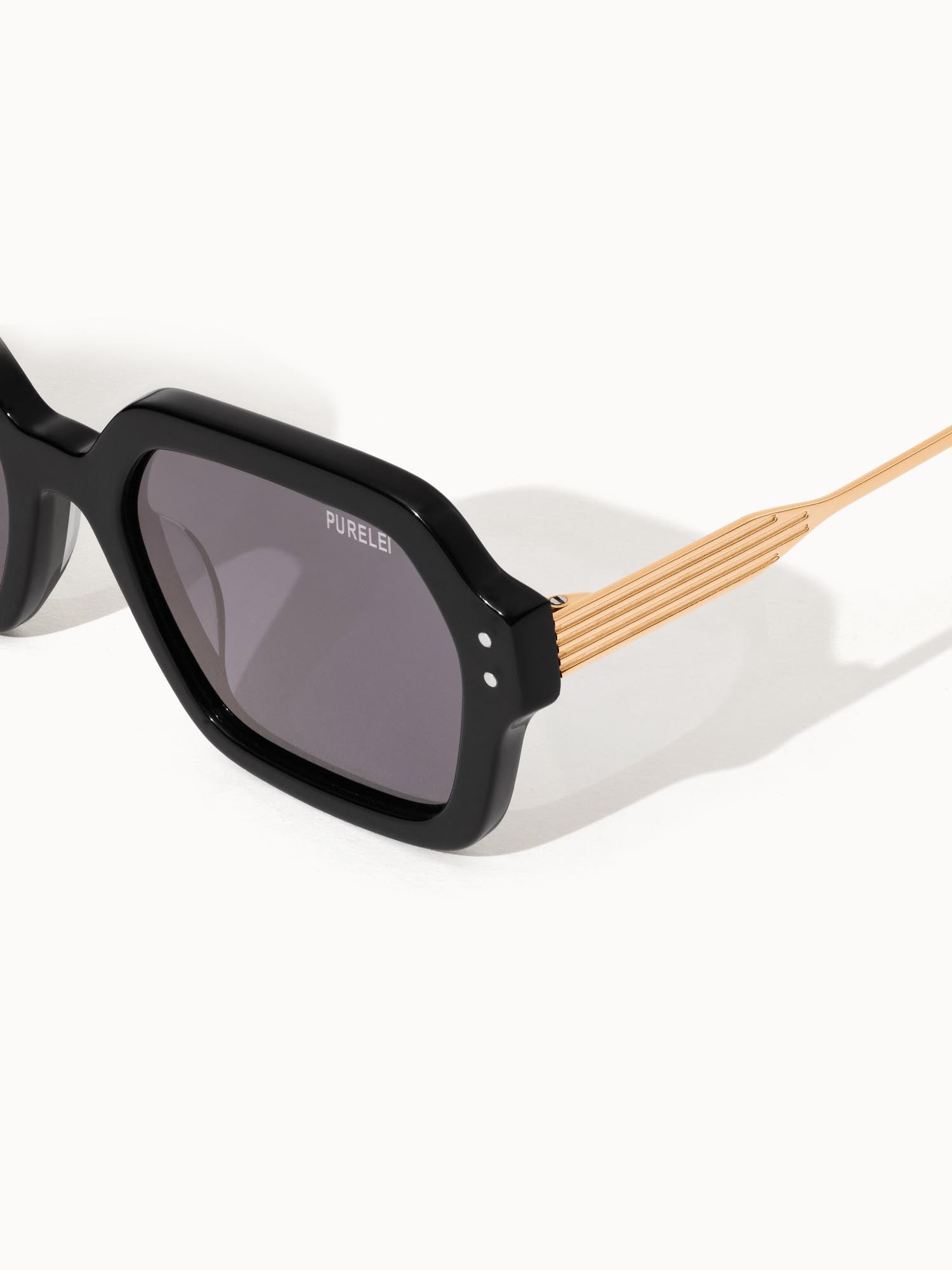 Coastal Core Sonnenbrille von PURELEI mit schwarzem Acetatgestell und goldfarbenem Metallbügel, elegant und modern.