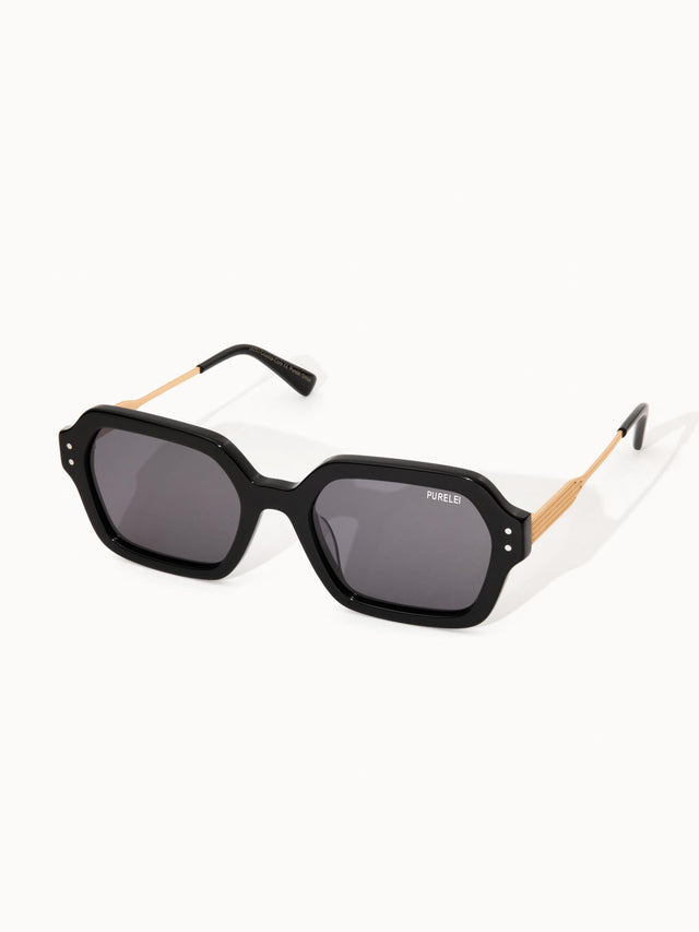 Schwarze Sonnenbrille mit goldenen Bügeln von PURELEI, modern und elegant.
