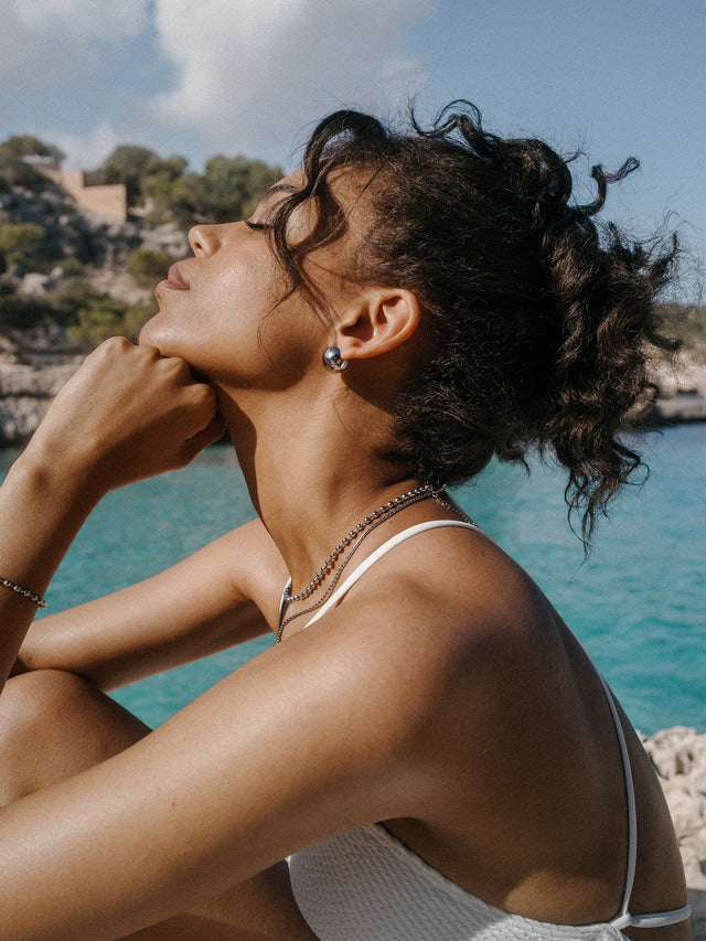 Elegante PURELEI Kette und Ohrringe, silberfarben, am Strand, tropische Stimmung.