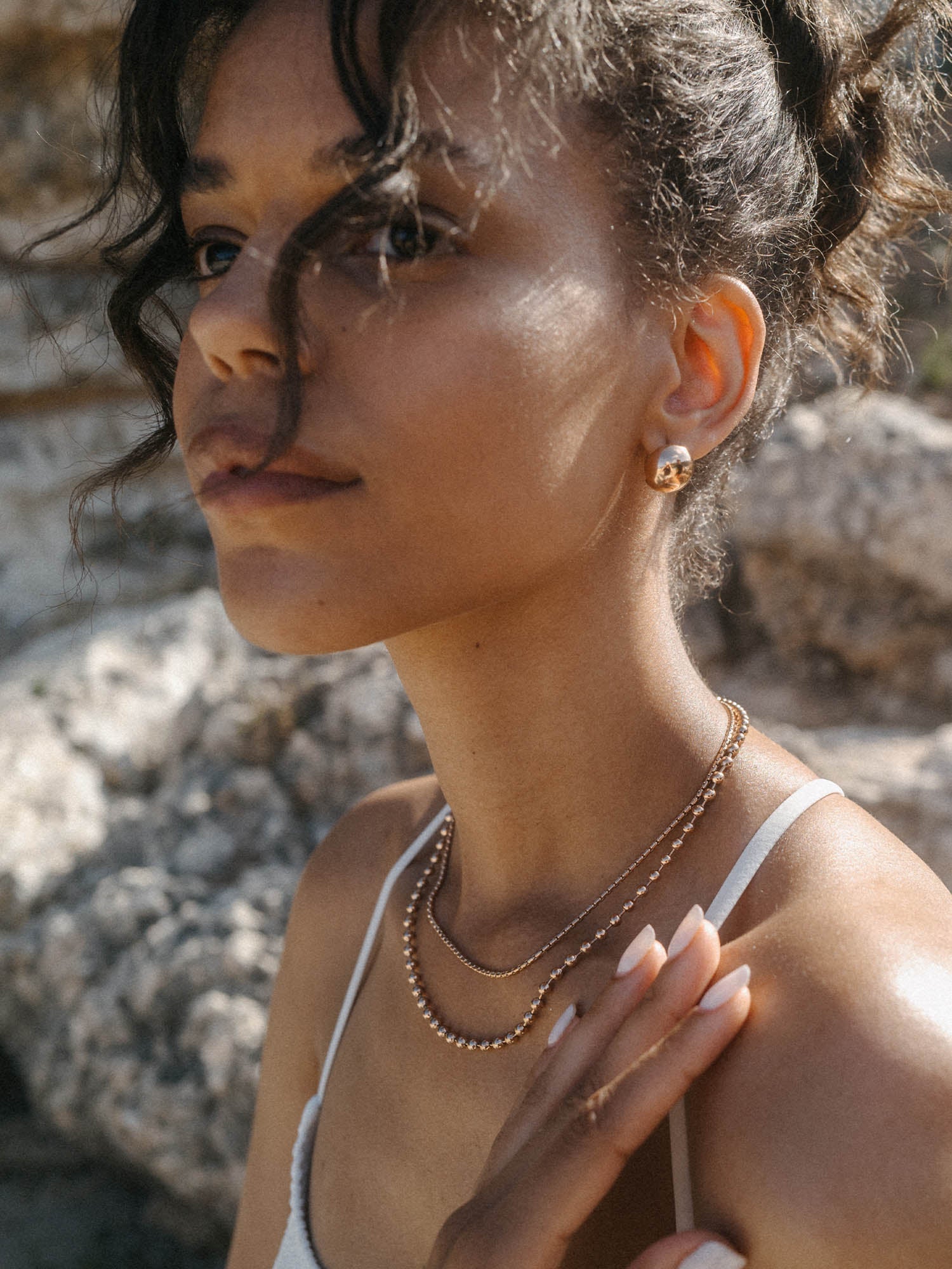 Zwei goldene Ketten von PURELEI, elegant und feminin, getragen am Hals mit natürlichem Licht.