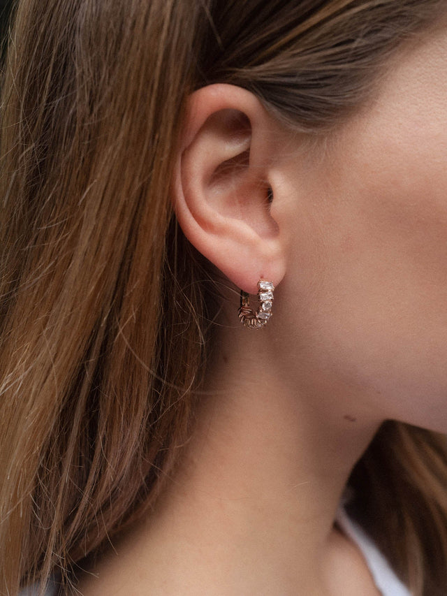 Roségoldene Creolen mit Muschel-Detail, getragen von einer Frau, PURELEI.