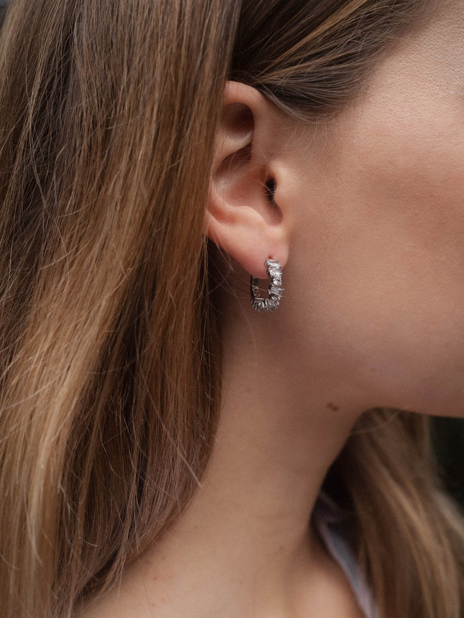 Roségoldene Creolen mit feinem Design, getragen am Ohr, von PURELEI.